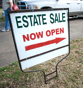 yard sign in lawn advertises an estate sale
